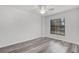 Simple bedroom with a window offering natural light and wood-style flooring at 1201 Groveland Dr, Chuluota, FL 32766