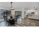Open-concept design featuring a dining area with black table set, wood floors, and natural light at 1201 Groveland Dr, Chuluota, FL 32766