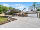 Tan single-story home featuring a carport, garage, and well-maintained landscaping at 1201 Groveland Dr, Chuluota, FL 32766