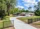 Single-story home with carport, long driveway, gated entrance, and well-maintained lawn with mature trees at 1201 Groveland Dr, Chuluota, FL 32766