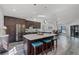 Modern kitchen with dark wood cabinets, stainless steel appliances, and an island with barstool seating at 1201 Groveland Dr, Chuluota, FL 32766