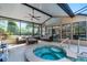Covered outdoor patio includes a spa, seating, and a ceiling fan overlooking the screened-in pool area at 1201 Groveland Dr, Chuluota, FL 32766