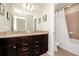 This bathroom offers a double vanity with granite countertops and a separate shower area, blending style and functionality at 1293 Emerald Row, Clermont, FL 34714