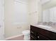 Well lit bathroom features a single sink vanity with granite countertops and wood drawers below at 1293 Emerald Row, Clermont, FL 34714