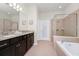 This bathroom features a soaking tub, a walk-in shower, and a double sink vanity with granite countertops at 1293 Emerald Row, Clermont, FL 34714