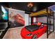 This unique bedroom showcases a race car bed, modern decor, and a flatscreen TV for an entertaining space at 1293 Emerald Row, Clermont, FL 34714
