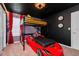 The bedroom features a lofted race car bed, sleek decor, and ample space, perfect for a young auto enthusiast at 1293 Emerald Row, Clermont, FL 34714