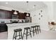 This kitchen features dark cabinets, stainless steel appliances, granite countertops, and pendant lighting above the island at 1293 Emerald Row, Clermont, FL 34714