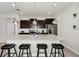 Kitchen island with dark cabinets, stainless appliances, granite counters, and bar stools at 1293 Emerald Row, Clermont, FL 34714