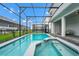 Beautiful in-ground pool and spa surrounded by screened enclosure and lush landscaping at 1293 Emerald Row, Clermont, FL 34714