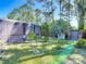 Landscaped backyard featuring a screened pool enclosure with storage sheds at 1296 Gage Ave, Deltona, FL 32738
