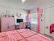 This bedroom features a pink bedspread, a pink wardrobe, and desk with computer at 1296 Gage Ave, Deltona, FL 32738