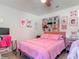 This bedroom has a gray bed, a pink comforter, and cute decorations on the walls at 1296 Gage Ave, Deltona, FL 32738