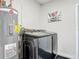 This laundry room has a modern black washer and dryer combo next to a hot water heater at 1296 Gage Ave, Deltona, FL 32738