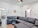 Bright living room featuring a large sectional sofa, wood-look flooring and comfortable seating at 1296 Gage Ave, Deltona, FL 32738