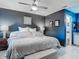 Bedroom features tile floors, ceiling fan, large windows and dark blue accent wall at 1296 Gage Ave, Deltona, FL 32738