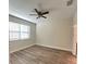 Bright bedroom with wood floors, a ceiling fan, and a large window, providing ample natural light at 14143 Title Way, Winter Garden, FL 34787