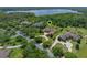 Aerial view of an estate home with lush landscaping, circular driveway, and a nearby lake at 1526 Bluewater Run, Chuluota, FL 32766
