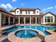 Resort-style backyard showcasing a pool, spa, outdoor living spaces, lush landscaping, and a grand home exterior at 1526 Bluewater Run, Chuluota, FL 32766