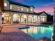 Luxury home with inviting outdoor pool area and covered patio overlooking beautifully maintained brick patio at 1526 Bluewater Run, Chuluota, FL 32766