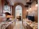Gourmet butler pantry featuring custom cabinetry, granite countertops, arched doorway and stainless steel sink at 1526 Bluewater Run, Chuluota, FL 32766