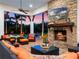 Inviting covered patio with stone fireplace, comfortable seating, and views of the pool and landscape at 1526 Bluewater Run, Chuluota, FL 32766