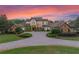 Elegant home with manicured landscaping, a circular driveway, and classic architectural details at sunset at 1526 Bluewater Run, Chuluota, FL 32766