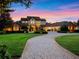 Elegant home with manicured landscaping, a circular driveway, and classic architectural details during twilight at 1526 Bluewater Run, Chuluota, FL 32766