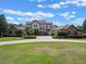 Spacious home exterior with landscaped yard, circular driveway, and classic architectural design at 1526 Bluewater Run, Chuluota, FL 32766