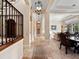 Elegant foyer features wrought iron staircase, travertine floors, and views into the living and dining rooms at 1526 Bluewater Run, Chuluota, FL 32766