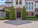 Up close view of front door with brick archway, manicured landscaping, and stone details at 1526 Bluewater Run, Chuluota, FL 32766