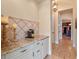 Hallway with granite counter and tile backsplash leading to a closet with custom shelves at 1526 Bluewater Run, Chuluota, FL 32766