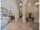 Long hallway with tile flooring, ornate light fixtures, and a dining room to the left at 1526 Bluewater Run, Chuluota, FL 32766