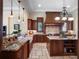 Chef's kitchen boasts custom cabinetry, granite counters, center island, tile floors, and modern appliances at 1526 Bluewater Run, Chuluota, FL 32766