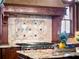 Close-up of kitchen with granite counters, tile backsplash, stainless steel appliances, and custom wood trim at 1526 Bluewater Run, Chuluota, FL 32766