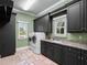 Laundry room features granite counters, tile floors, modern washer and dryer and dark cabinets at 1526 Bluewater Run, Chuluota, FL 32766