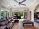 Open living room featuring tile floors, leather furniture, and access to an outdoor living space at 1526 Bluewater Run, Chuluota, FL 32766
