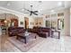 Bright living room features elegant coffered ceilings, tile floors, and comfortable leather furniture at 1526 Bluewater Run, Chuluota, FL 32766