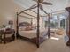 Main bedroom boasts a four-poster bed, sitting area, backyard views, and elegant lighting at 1526 Bluewater Run, Chuluota, FL 32766
