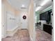 Mudroom with bench seating and hooks, transitioning to the laundry room with black cabinets at 1526 Bluewater Run, Chuluota, FL 32766