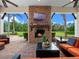 Relaxing covered patio with a stone fireplace, comfortable seating, and view of the lush backyard at 1526 Bluewater Run, Chuluota, FL 32766