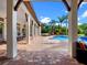 Stylish outdoor patio with brick flooring, support columns, with pool, spa, and palm tree views at 1526 Bluewater Run, Chuluota, FL 32766