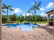 Inviting pool featuring a spa, brick patio, palm trees, and lush landscaping for an exceptional outdoor experience at 1526 Bluewater Run, Chuluota, FL 32766
