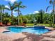 Backyard swimming pool with brick patio, fountain feature, palm trees, and lounge chairs at 1526 Bluewater Run, Chuluota, FL 32766