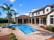 Expansive backyard showcasing a large pool, spa, mature palm trees, and a well-manicured lawn at 1526 Bluewater Run, Chuluota, FL 32766