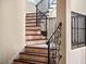 Staircase features decorative wrought iron railing and wood and tile steps, with plenty of natural light at 1526 Bluewater Run, Chuluota, FL 32766