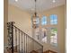 Staircase landing with decorative wrought iron railing and large windows overlooking the manicured lawn at 1526 Bluewater Run, Chuluota, FL 32766