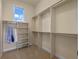 Bright walk-in closet featuring custom shelving and ample hanging space, illuminated by a natural light window at 1526 Bluewater Run, Chuluota, FL 32766