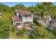 Aerial view of a two-story home with a tile roof, a private backyard pool, patio, and lush landscaping at 1665 Temple Dr, Winter Park, FL 32789