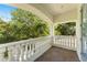 This stylish balcony features tan tile, white railings and columns, and views of mature landscaping and lush trees at 1665 Temple Dr, Winter Park, FL 32789